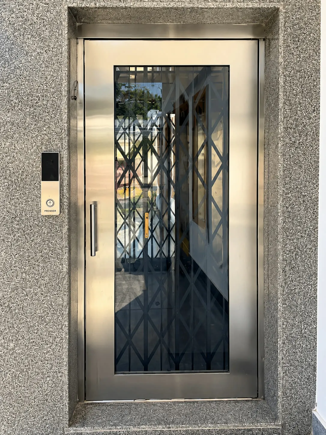 Home lift landing with a stainless door in a granite surround